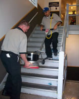 Custodians Moving Stripping and Waxing machine Down Stairs